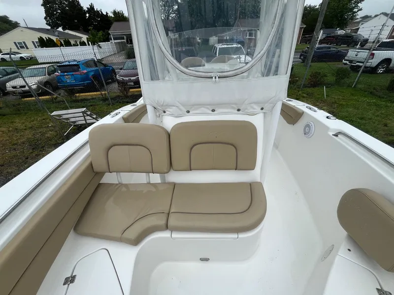 Slide: The Image of 2017 Tidewater 230 LXF boat interior with beige seating and clear enclosure. - 11