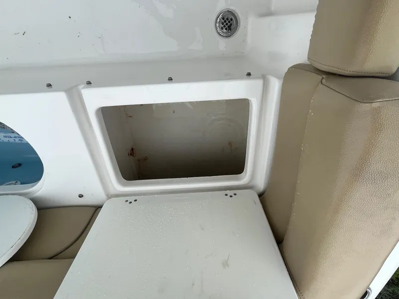 Slide: The Image of 2017 Tidewater 230 LXF boat interior with storage compartment and beige seating. - 14