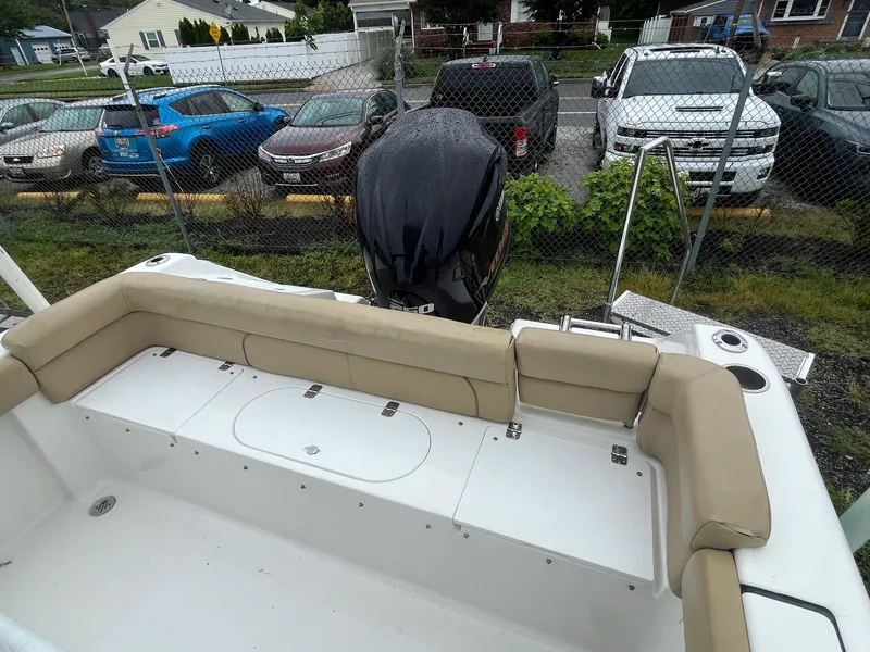 Slide: The Image of 2017 Tidewater 230 LXF boat with beige seating, parked near a fence. - 15