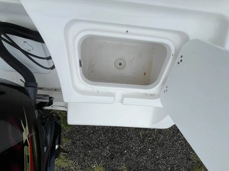 Slide: The Image of 2017 Tidewater 230 LXF boat compartment with open lid and visible engine components. - 16