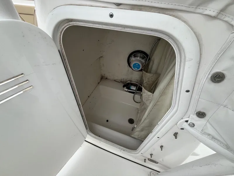 Slide: The Image of Storage compartment inside a 2017 Tidewater 230 LXF boat, featuring a speaker and pump. - 19