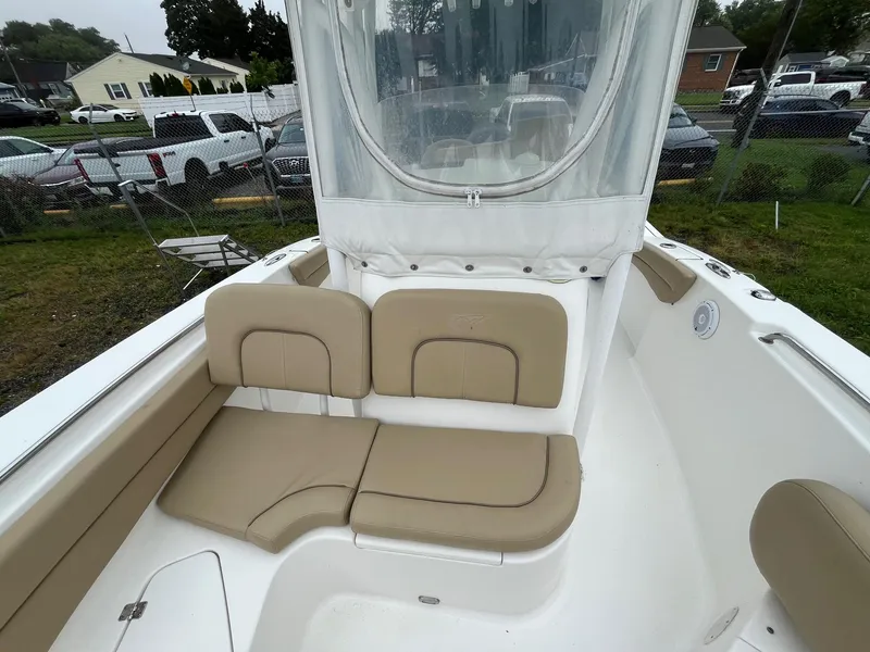 Slide: The Image of 2017 Tidewater 230 LXF boat interior with beige seating and protective cover. - 23