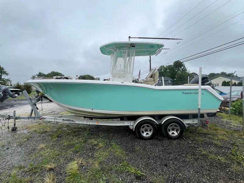 Slide: The Image of 2017 Tidewater 230 LXF boat on trailer, light blue hull, overcast sky. - 4