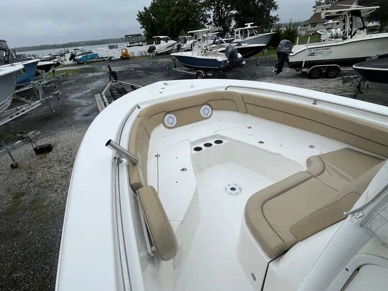 Slide: The Image of 2017 Tidewater 230 LXF boat with beige seating, docked among other boats. - 6