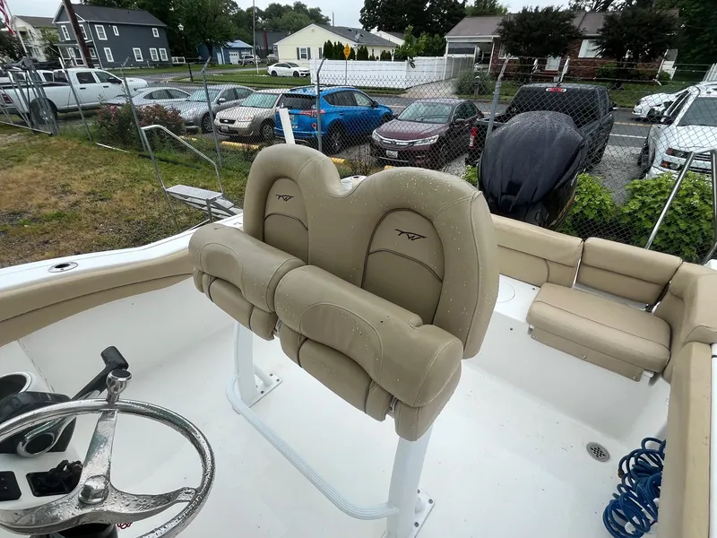 Slide: The Image of 2017 Tidewater 230 LXF boat interior with beige seating and steering wheel. - 7