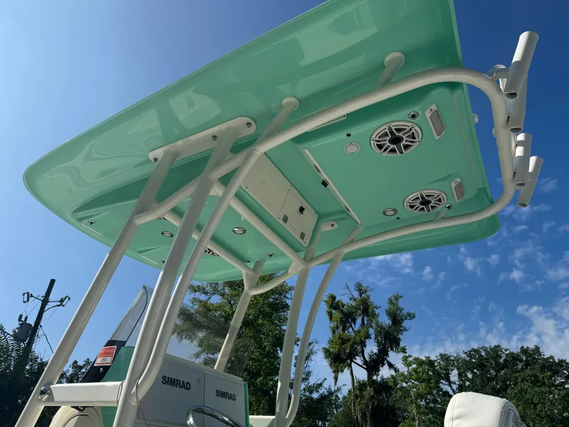 Slide: The Image of 2020 ShearWater 250 boat with teal T-top and speakers, under a clear blue sky. - 13