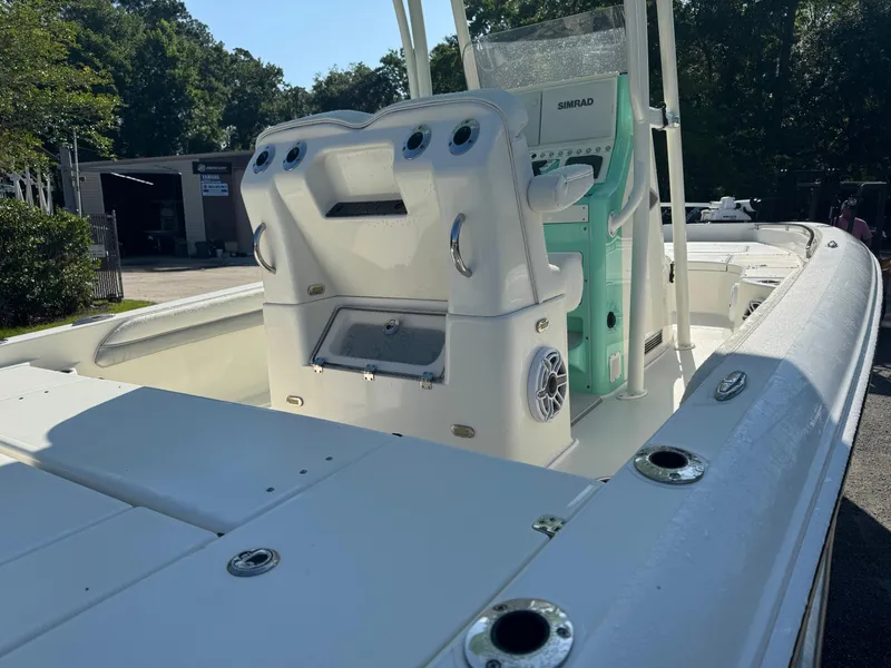 Slide: The Image of 2020 ShearWater 250 boat interior with console and seating, parked outdoors. - 14