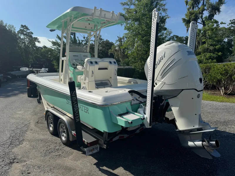 Slide: The Image of 2020 ShearWater 250 boat on trailer with powerful outboard motor, parked outdoors. - 5