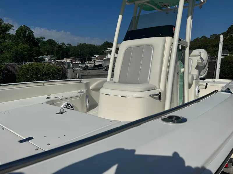 Slide: The Image of 2020 ShearWater 250 boat interior with seating and console, docked under clear blue sky. - 7