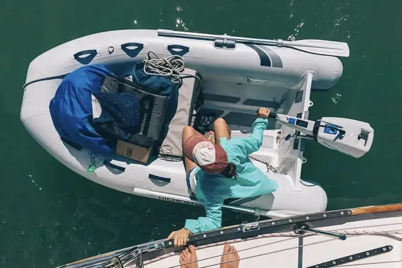 Slide: The Image of 2025 Highfield Ultralite 240SS inflatable boat with person and gear on water. - 1