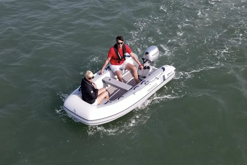 The Image of 2024 Highfield Classic 260 inflatable boat with two people navigating on water. - 0