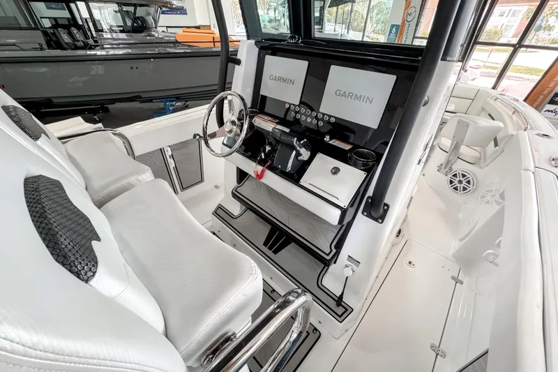 Slide: The Image of 2024 Wellcraft 263 Fisherman boat cockpit with dual Garmin displays and white seating. - 12