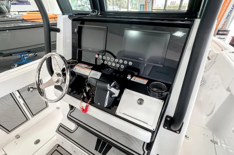 Slide: The Image of 2024 Wellcraft 263 Fisherman boat dashboard with steering wheel and navigation screens. - 13