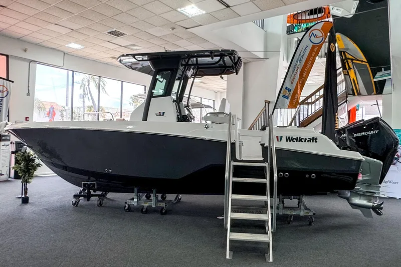 Slide: The Image of 2024 Wellcraft 263 Fisherman boat displayed indoors with Mercury engine. - 2