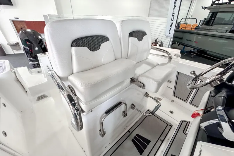 Slide: The Image of 2024 Wellcraft 263 Fisherman boat interior with dual white captain seats and steering wheel. - 21