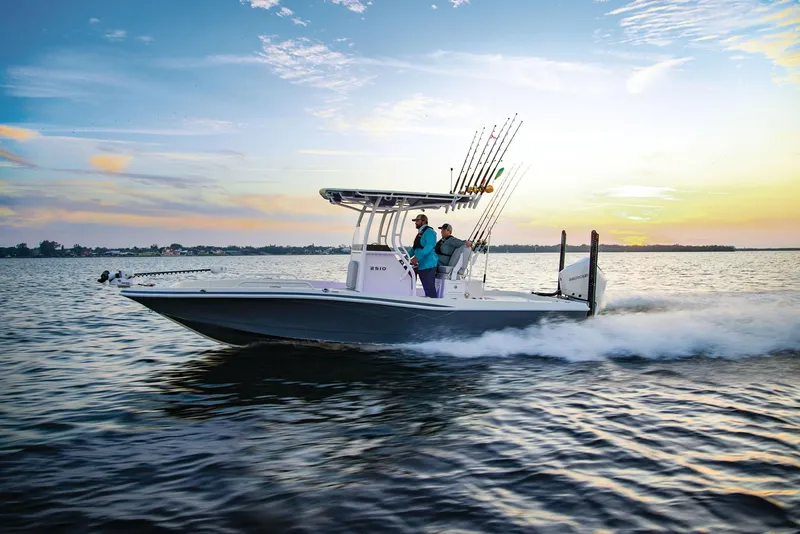 The Image of 2025 Ranger 2510 Bay boat on trailer, parked outdoors under clear blue sky. - 1