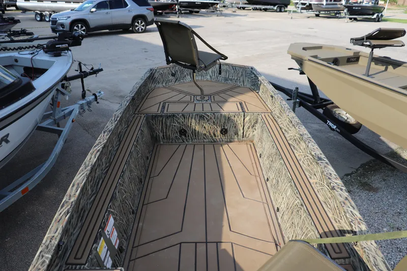 Slide: The Image of 2025 Tracker Grizzly 1650 T Prairie Wings Edition boat with camouflage interior, parked outdoors. - 3