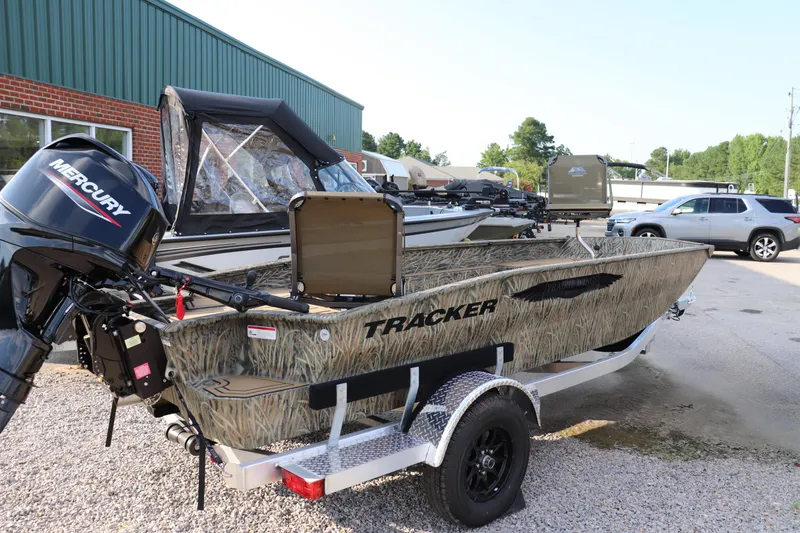 Slide: The Image of 2025 Tracker Grizzly 1650 T Prairie Wings Edition boat with Mercury engine, parked outdoors. - 5