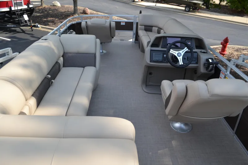 Slide: The Image of 2025 Sun Tracker SportFish 20 DLX pontoon boat interior with beige seating and steering console. - 4