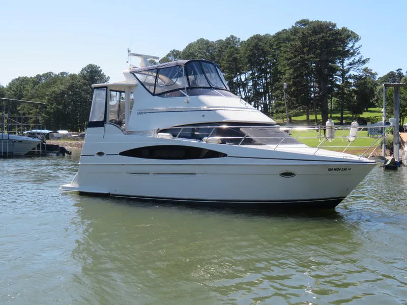 Slide: The Image of 2003 Carver 366 Motor Yacht docked on a sunny day with trees in the background. - 1