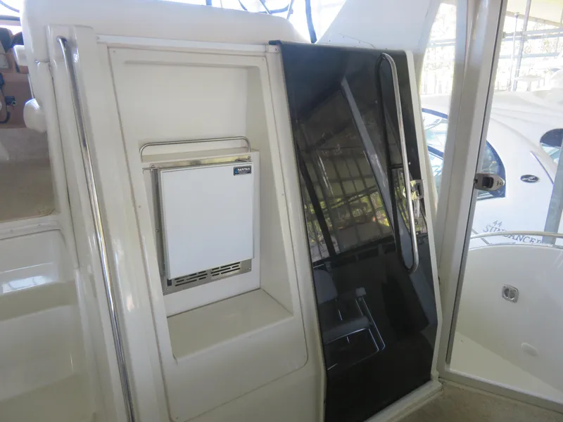 Slide: The Image of 2003 Carver 366 Motor Yacht interior with compact refrigerator and sleek black door. - 11