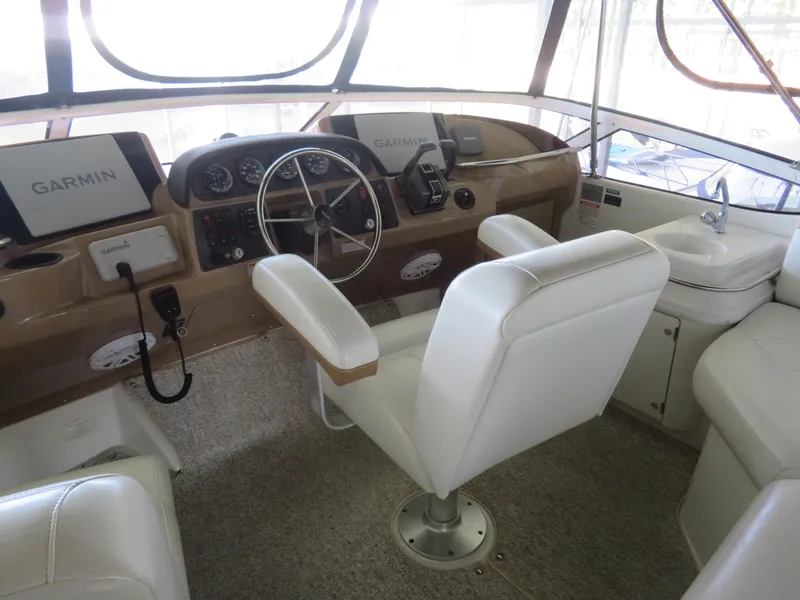 Slide: The Image of 2003 Carver 366 Motor Yacht helm with Garmin navigation, white seating, and steering wheel. - 12