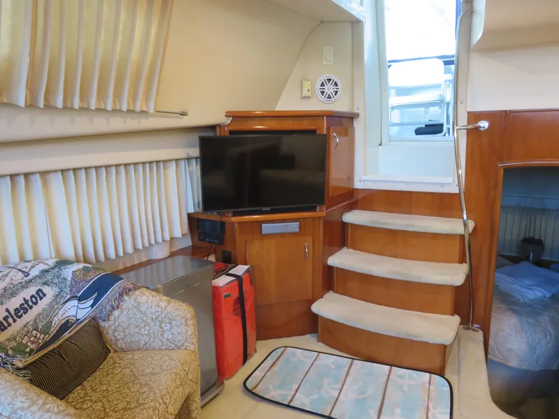 Slide: The Image of Interior of 2003 Carver 366 Motor Yacht with TV, stairs, and cozy seating area. - 14