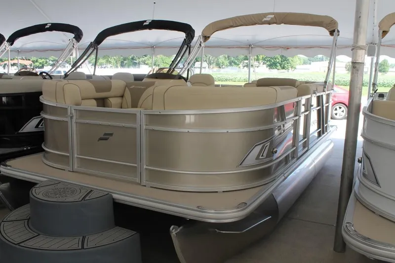 Slide: The Image of 2025 Starcraft EX 18 pontoon boat with beige seating under a canopy. - 1