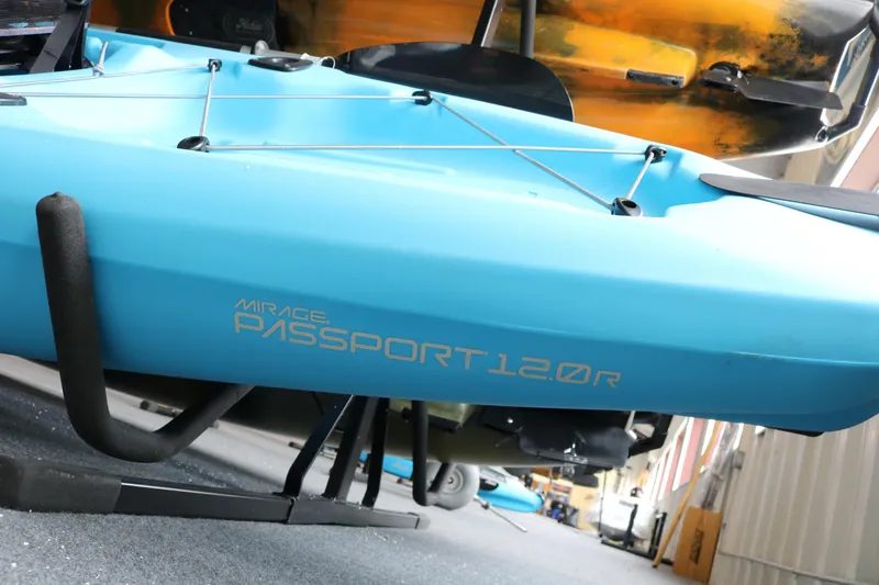 Slide: The Image of 2024 Hobie Mirage Passport 12.0 R kayak in vibrant blue on display stand. - 2