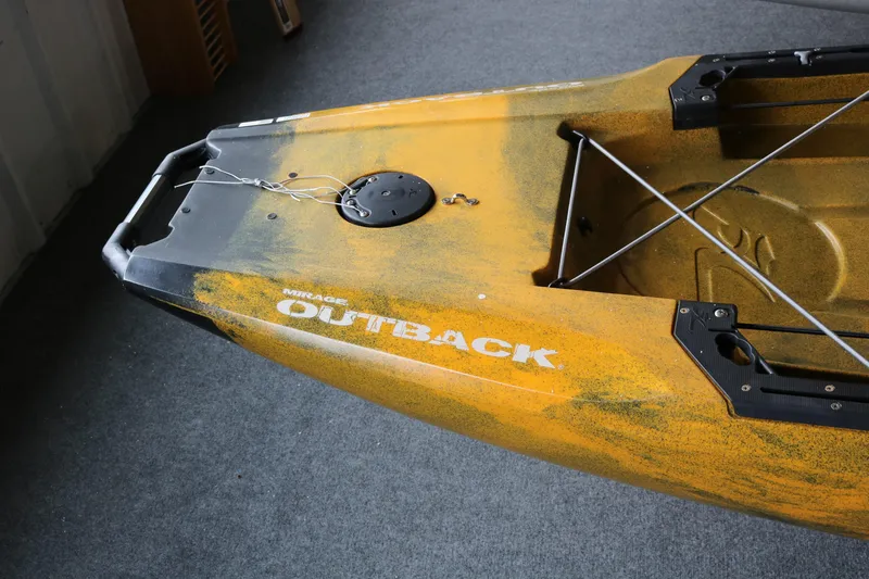 Slide: The Image of 2024 Hobie Mirage Outback kayak, yellow with black accents, on a gray carpeted floor. - 4