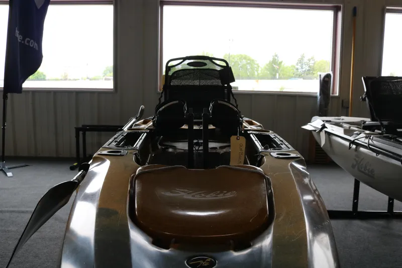 Slide: The Image of 2024 Hobie Mirage Outback kayak displayed indoors with seating and pedal system. - 5