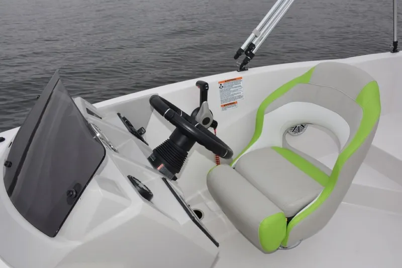 Slide: The Image of 2025 Starcraft 191 SVX OB boat cockpit with steering wheel and green-accented seat. - 10