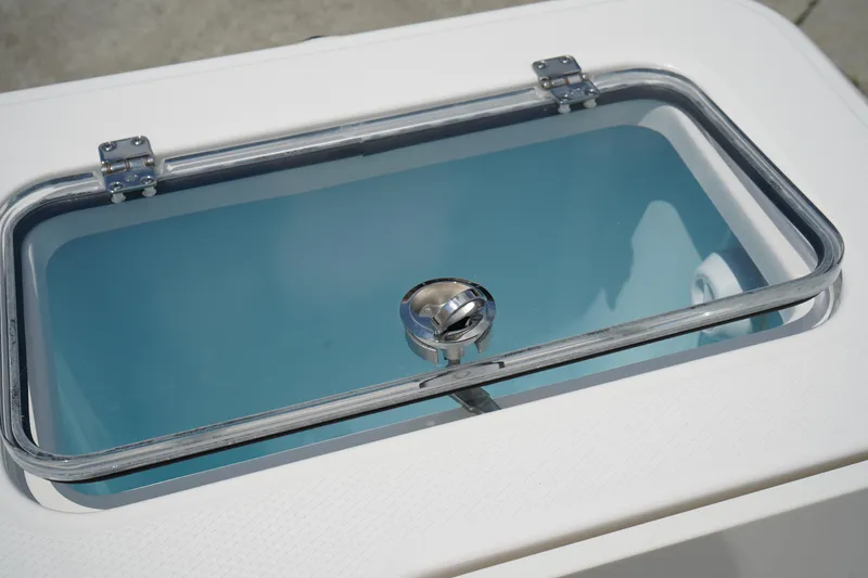 Slide: The Image of 2025 Robalo R300 Center Console livewell with clear lid and stainless steel handle. - 13