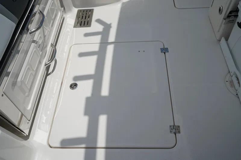 Slide: The Image of 2025 Robalo R300 Center Console deck with storage hatch and rod holders. - 14
