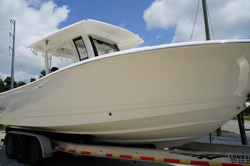 Slide: The Image of 2025 Robalo R300 Center Console boat on trailer under blue sky. - 2