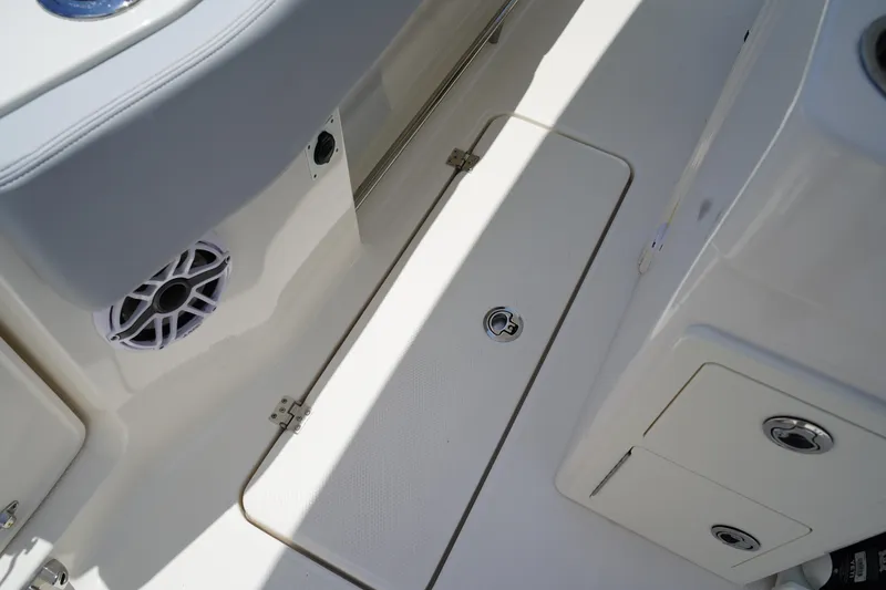 Slide: The Image of 2025 Robalo R300 Center Console boat deck with storage compartments and speaker. - 26