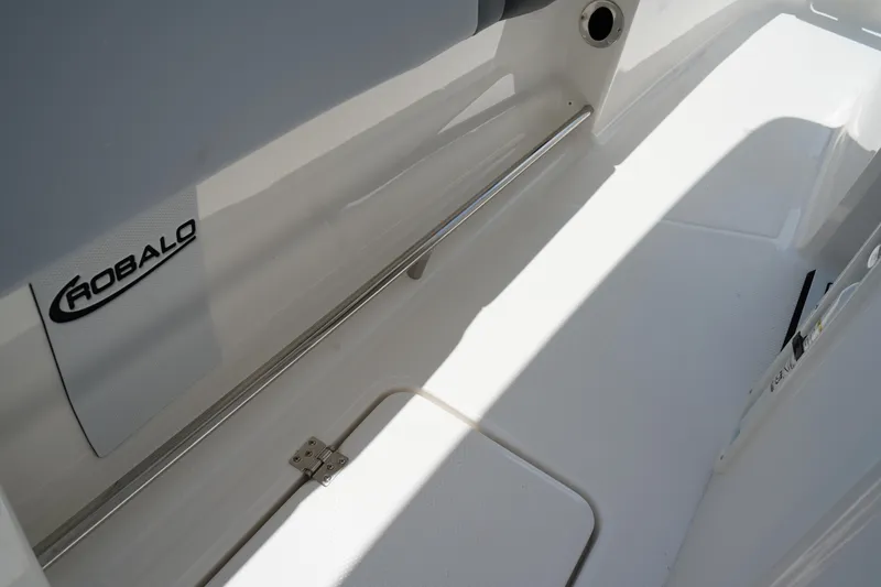 Slide: The Image of 2025 Robalo R300 Center Console interior detail with logo and storage compartment. - 28