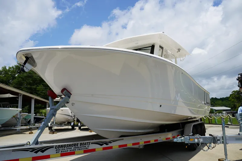 Slide: The Image of 2025 Robalo R300 Center Console boat on trailer under cloudy sky. - 3