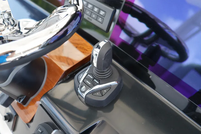 Slide: The Image of 2025 Robalo R300 Center Console boat joystick control and steering wheel detail. - 36