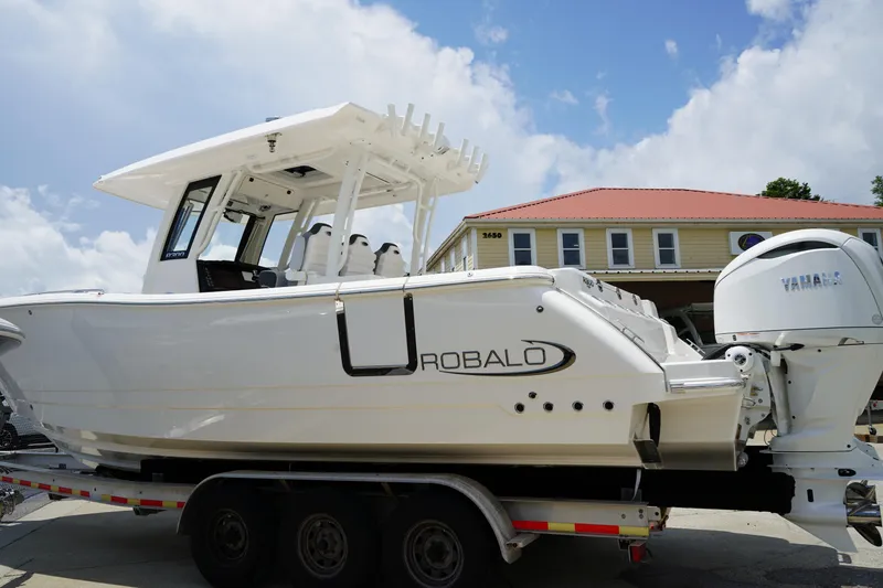 Slide: The Image of 2025 Robalo R300 Center Console boat on trailer, featuring Yamaha engine, against a cloudy sky. - 4