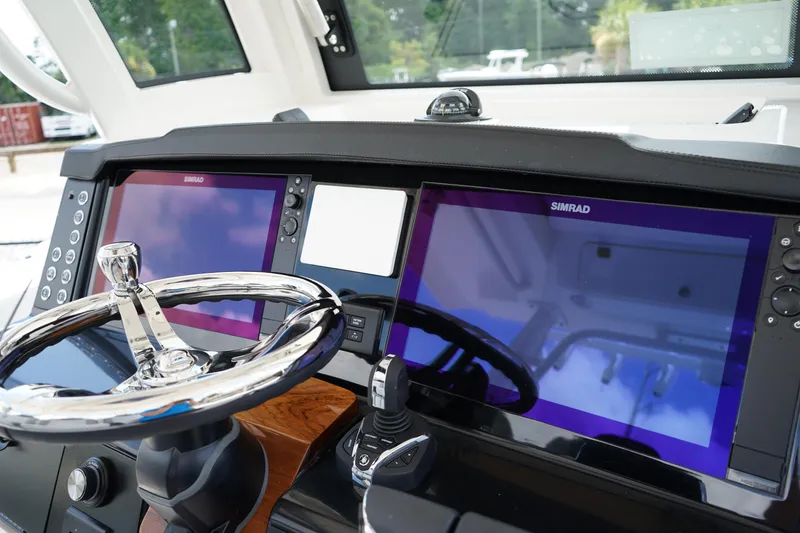 Slide: The Image of 2025 Robalo R300 Center Console dashboard with dual Simrad displays and chrome steering wheel. - 41