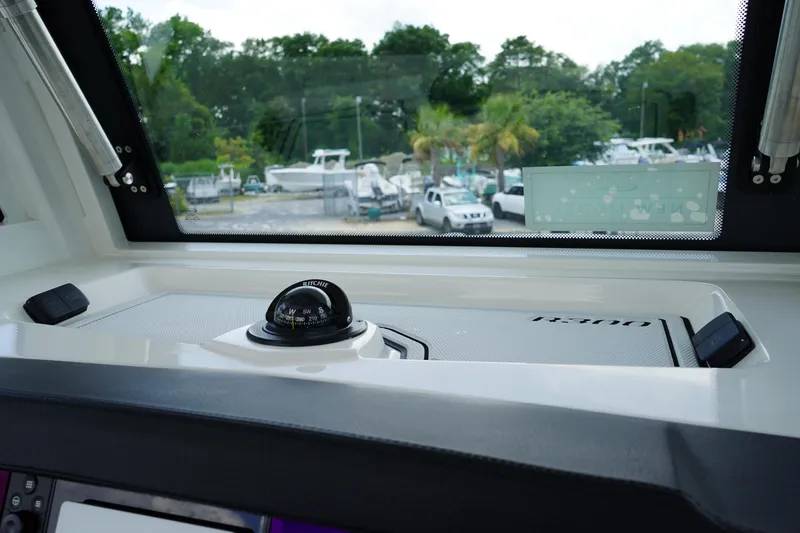 Slide: The Image of 2025 Robalo R300 Center Console boat interior with compass and dashboard view. - 43