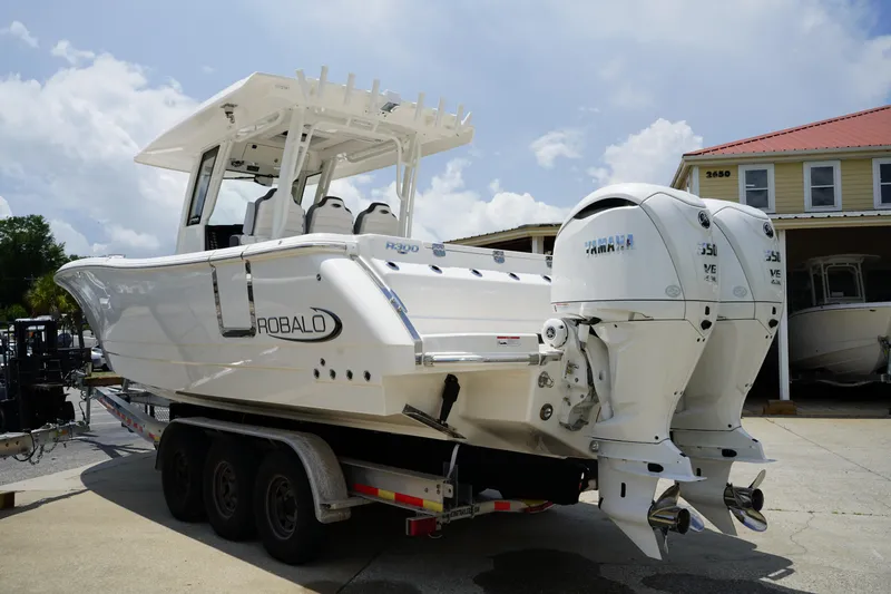 Slide: The Image of 2025 Robalo R300 Center Console boat with dual Yamaha engines on a trailer. - 6