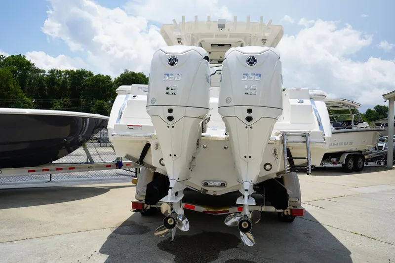 Slide: The Image of 2025 Robalo R300 Center Console with dual outboard engines, parked outdoors. - 7