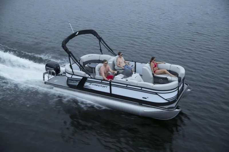 Slide: The Image of 2025 Starcraft SLS 1 pontoon boat cruising on a lake with passengers. - 5
