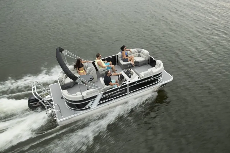 Slide: The Image of 2025 Starcraft EX 20 pontoon boat cruising with passengers on a lake. - 1