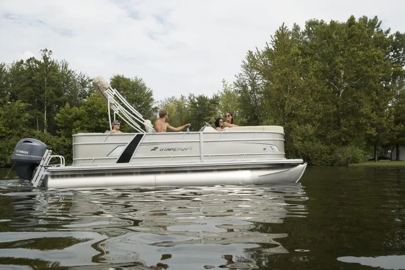 Slide: The Image of 2025 Starcraft EX 20 pontoon boat on a calm lake with passengers enjoying the ride. - 5