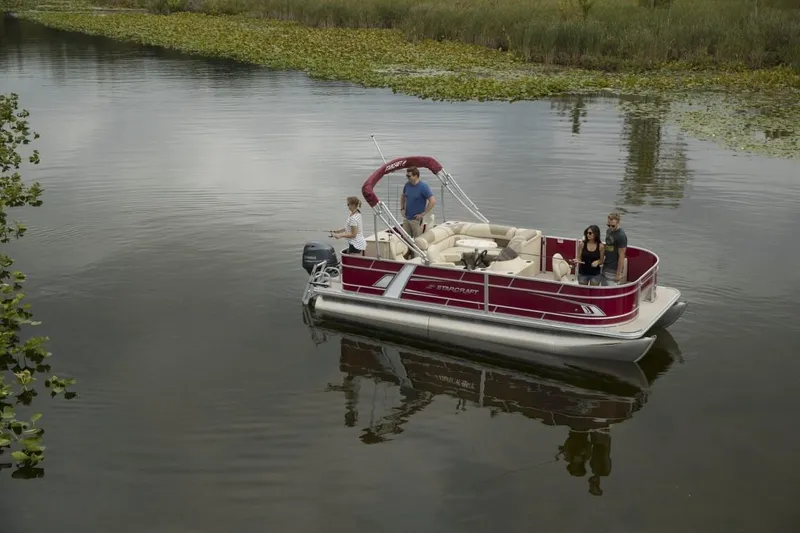 Slide: The Image of 2025 Starcraft EX 20 pontoon boat on a calm lake with passengers enjoying the ride. - 7