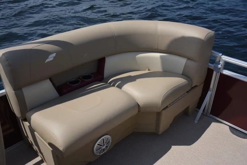 Slide: The Image of 2025 Starcraft 20 LX boat with beige seating, cup holders, and speaker on a calm lake. - 7