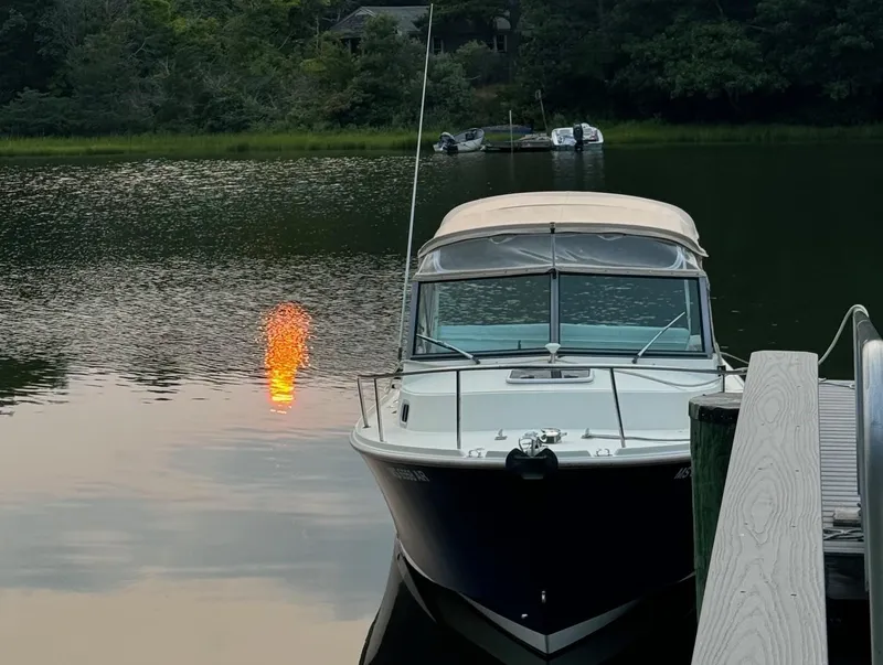 Slide: The Image of Holby 24 Pilot boat docked on a serene lake at sunset, 2005 model. - 15